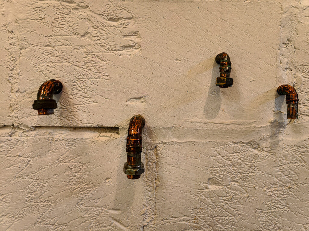 Pipe-based sculptural installation exploring masculinity, industrial infrastructure and queer material aesthetics